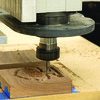 This CNC router machine, one available to Tri-County students, cuts a programmed tree shape into wood. According to multiple sources, a CNC machine is an automated milling device that manufactures industrial components without direct human assistance, but that does use coded instructions sent to a computer. They cut or move material as programmed and are used in various industries, such as metalworking, woodworking and 3-D printing.